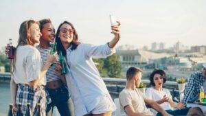 Friends taking a selfie at a rooftop party - perfect setting for truth or dare games