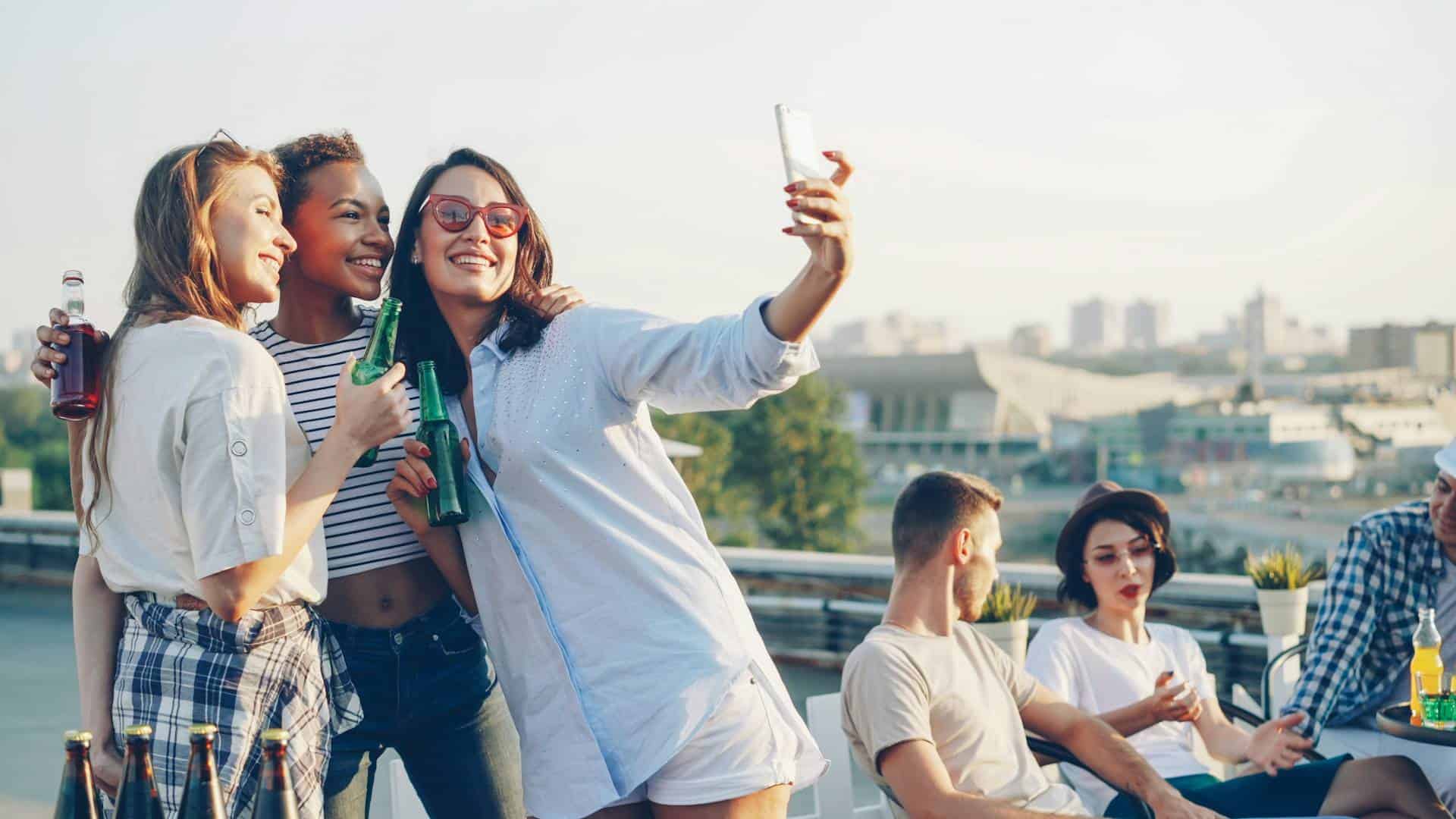Friends taking a selfie at a rooftop party - perfect setting for truth or dare games